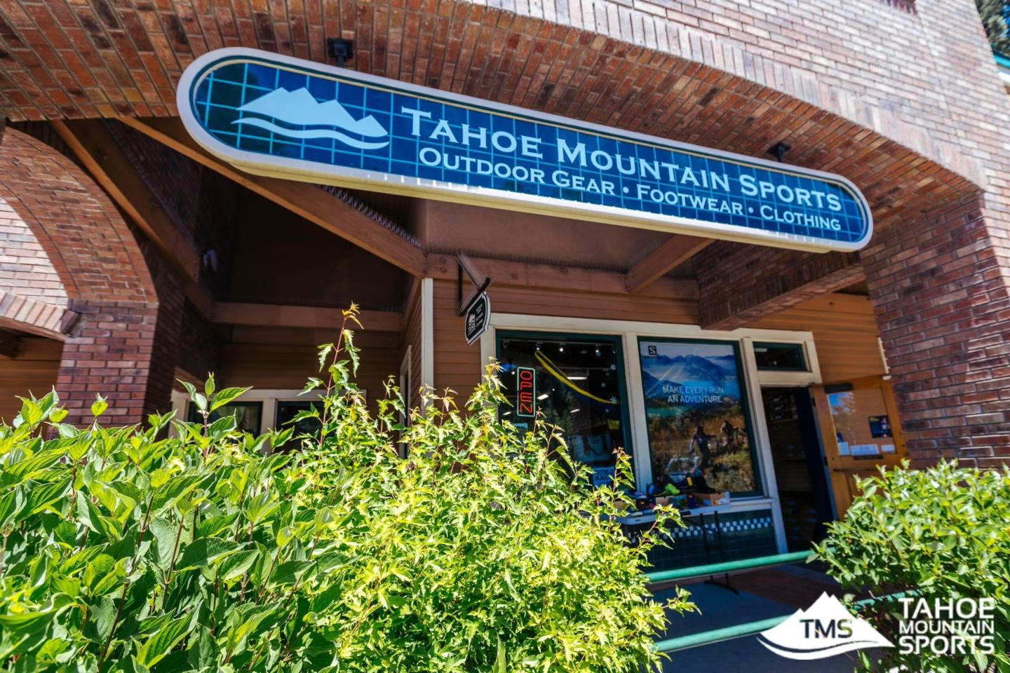 Tahoe Mountain Sports storefront with blue sign, bicycles, and green shrubs
