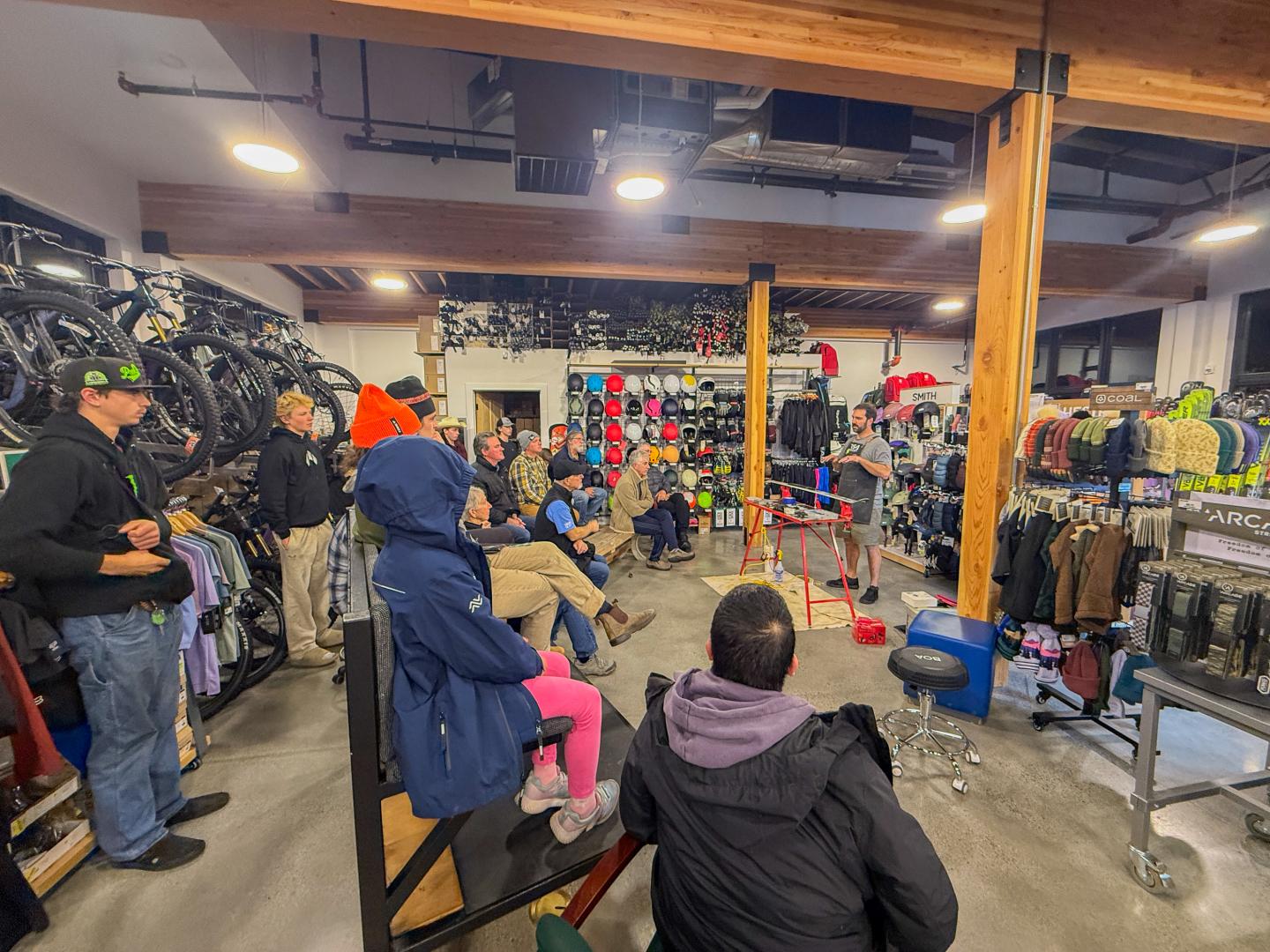 Customers browse bicycles and gear inside a crowded bike shop.