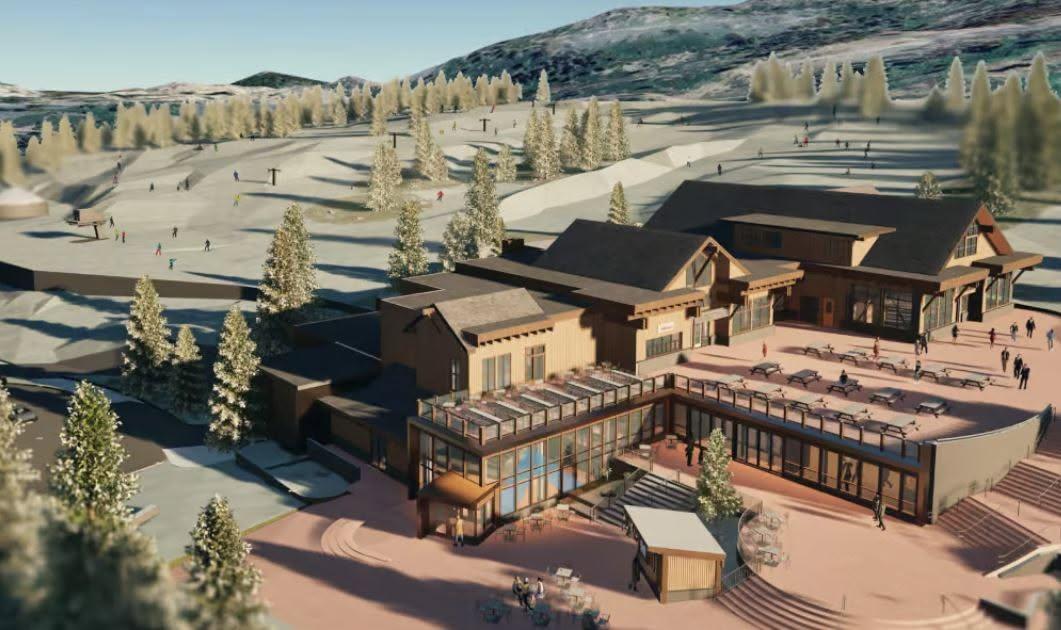 Aerial view of a rustic mountain lodge complex surrounded by snowy pine forest