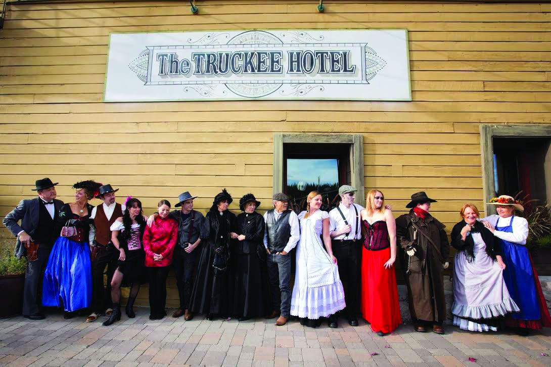 Group in period costumes outside the wooden Truckee Hotel.